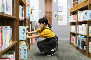 返却された本を本棚に戻す「配架」に取り組む小学生