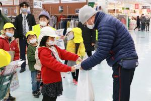 来客にゆずを手渡す園児